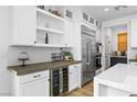 Bright kitchen featuring white cabinetry, stainless steel appliances, beverage fridge, and a stylish backsplash at 2710 Marchetti Pl, Henderson, NV 89044