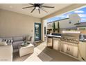 Covered outdoor kitchen with built-in grill, fridge, and ample counter space, perfect for entertaining guests at 2710 Marchetti Pl, Henderson, NV 89044