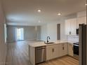 Modern kitchen with white cabinets, stainless steel appliances, and an open concept layout at 3212 Walker River St, North Las Vegas, NV 89032