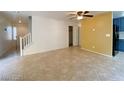 Open living space with tiled flooring, stairs, and view into the kitchen at 3311 Fico Ave, Las Vegas, NV 89141