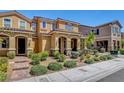 Exterior view of tan homes featuring tidy landscaping, covered entryways and attractive facades at 3514 Punta Tersiva Ln, Henderson, NV 89044