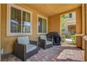 Covered patio featuring comfortable seating, a small table, and shade for relaxing outdoors at 3514 Punta Tersiva Ln, Henderson, NV 89044