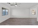 Spacious living room filled with natural light highlighting gray flooring, and a modern ceiling fan fixture at 4219 Gold Desert St, North Las Vegas, NV 89032