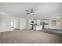 Spacious living area featuring a ceiling fan and open floor plan into the kitchen and dining area at 4223 Gold Desert St, North Las Vegas, NV 89032