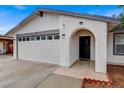 Close-up of a single-story home featuring a two-car garage and an arched front entryway at 4430 Eureka Cir, Las Vegas, NV 89103