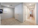 Neutral hallway featuring tile flooring, storage closets, and doors that lead to other rooms at 4436 Hatch Bend Ave, North Las Vegas, NV 89031