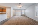 Open concept living room featuring a ceiling fan, light-colored walls, plush carpet, and a sliding glass door at 4436 Hatch Bend Ave, North Las Vegas, NV 89031