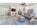 Open-concept living room with fireplace, stylish floors, and abundant natural light at 4515 Sandstone Vista Ct, North Las Vegas, NV 89031