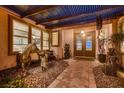 Inviting home entrance with a covered patio featuring decorative statues, desert-themed landscaping, and a beautiful double door at 4980 Pensier St, Las Vegas, NV 89135