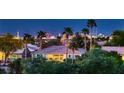 Exterior shot of the home and its community, highlighting lush landscaping, palm trees and a view of the Las Vegas skyline at 4980 Pensier St, Las Vegas, NV 89135