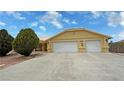 Exterior view of home featuring a spacious two-car garage and ample driveway space at 6460 Wagon Wheel Ct, Pahrump, NV 89061