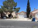 Single-story home with two-car garage, desert landscaping, and a terra cotta tiled roof under a clear sky at 6512 Sterling Springs Pkwy, Las Vegas, NV 89108