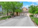 Inviting single-story home with a spacious driveway, a two-car garage, and lush landscaping at 6631 Creeping Thyme St, Las Vegas, NV 89148