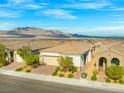 An aerial view of a desert home showcases mountain views, tiled roof, and low-maintenance landscaping at 8668 Marcana St, Las Vegas, NV 89166