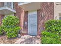 Charming brick townhome exterior features well maintained landscaping and secure front door at 1034 Tam O Shanter, Las Vegas, NV 89109