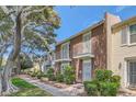 Brick townhome exterior features symmetrical balconies and mature trees, on a bright day at 1034 Tam O Shanter, Las Vegas, NV 89109