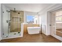 Bathroom showcases a glass-enclosed shower, freestanding tub, and a large window with a scenic view at 1136 Casady Hollow Ave, Henderson, NV 89012