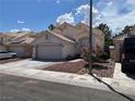 Charming single-story home with a two-car garage, red rock landscaping and tile roof at 1249 Lucia Dr, Las Vegas, NV 89128