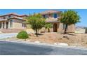 Charming two-story home with tan stucco, desert landscaping, and a welcoming front entrance at 16 Goldleaf Falls Ave, North Las Vegas, NV 89031