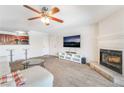 Carpeted living room featuring a fireplace, ceiling fan, and access to an open kitchen with breakfast bar at 2451 N Rainbow Blvd # 2131, Las Vegas, NV 89108