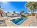 Backyard features a sparkling blue pool, covered patio, artificial grass area, and low-maintenance landscaping at 2529 Indian Sage Way, Las Vegas, NV 89108