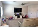 Bright living room with carpet flooring, ceiling fan, a white-paneled accent wall, and ample natural light at 2585 Amazing Meadows Ave # 1007, North Las Vegas, NV 89031