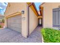 Inviting home entrance with a paved walkway leading to a covered front door and a two-car garage at 2601 Bechamel Pl, Henderson, NV 89044