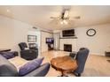 Comfortable living room featuring hardwood floors, a ceiling fan, a brick fireplace, and stylish furnishings at 2748 Heritage Cir, Las Vegas, NV 89121