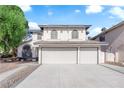 View of the home's facade, showcasing its grand entrance and a three-car garage for ample parking at 2808 Deep Water Cir, Las Vegas, NV 89117