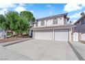 Spacious home with a three-car garage and lush landscaping offering excellent curb appeal at 2808 Deep Water Cir, Las Vegas, NV 89117