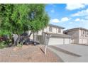 Front exterior view of home, highlighting the lush greenery, and a three-car garage at 2808 Deep Water Cir, Las Vegas, NV 89117