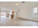 Open living area featuring modern wood flooring, white walls, and access to the kitchen and backyard at 4045 Oliver Sagebrush Dr, Las Vegas, NV 89122