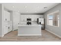 Modern kitchen with white cabinets, stainless steel appliances, and a center island with marble countertop at 4405 Pioche Ave, North Las Vegas, NV 89032