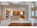 Spacious open-concept kitchen with island, tile floors, granite countertops and stainless steel appliances at 5405 Ireland St, Las Vegas, NV 89149