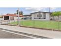 Exterior shot showing the side of the house with a fenced yard and green grass at 6437 Burgundy Way, Las Vegas, NV 89107