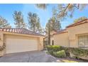 Charming home exterior featuring well-maintained landscaping, a red tile roof, and an attached garage at 6961 Emerald Springs Ln, Las Vegas, NV 89113