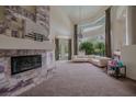 Bright living room featuring a fireplace, a large window, and a comfortable L-shaped couch with views of the manicured yard at 72 Innisbrook Ave, Las Vegas, NV 89113