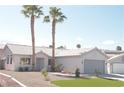Inviting single-story home featuring desert landscaping, palm trees, and a two-car garage at 7413 Red Eagle St, Las Vegas, NV 89131