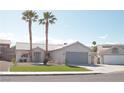 Single-story home featuring desert landscaping, palm trees, and a two-car garage at 7413 Red Eagle St, Las Vegas, NV 89131