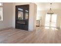 Bright living room featuring wood floors, black marble fireplace, and double doors to the patio at 7413 Red Eagle St, Las Vegas, NV 89131