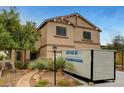 Two-story home with desert landscaping and a portable storage container on the driveway at 9017 Wolf Dancer Ave, Las Vegas, NV 89143