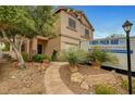 Charming two-story home with desert landscaping and a stone walkway leading to the front door at 9017 Wolf Dancer Ave, Las Vegas, NV 89143