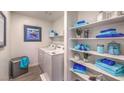 Well-organized laundry room with shelving, washer, dryer, and blue decor and accents at 4755 Bluebird Cliffs Ave Dr # Lot 173, Las Vegas, NV 89141
