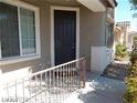 Inviting front entrance with a dark-colored door, convenient railing, and nice landscaping at 1004 Windy Ferrell Ave, North Las Vegas, NV 89081