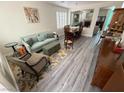 Bright living room featuring hardwood floors, comfortable seating, and a view into the dining area at 10071 Lemon Valley Ave, Las Vegas, NV 89147