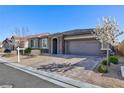 Charming single-story home with stone accents, a two-car garage, and manicured landscaped front yard at 10095 Ferton Lake Ave, Las Vegas, NV 89178