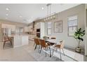 Open dining area with modern light fixture, seating for six, and adjacent to a modern kitchen at 10251 Tiger Milkweed St, Las Vegas, NV 89141