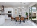 Well-lit dining area with modern light fixture, adjacent to the kitchen and a sliding door to the backyard at 10251 Tiger Milkweed St, Las Vegas, NV 89141