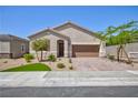 Charming single-story home with a brick driveway, two-car garage, desert landscaping, and an inviting entrance at 10251 Tiger Milkweed St, Las Vegas, NV 89141
