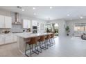 Open kitchen and living space featuring white cabinets, stainless appliances, a kitchen island with seating, and bright natural light at 10251 Tiger Milkweed St, Las Vegas, NV 89141